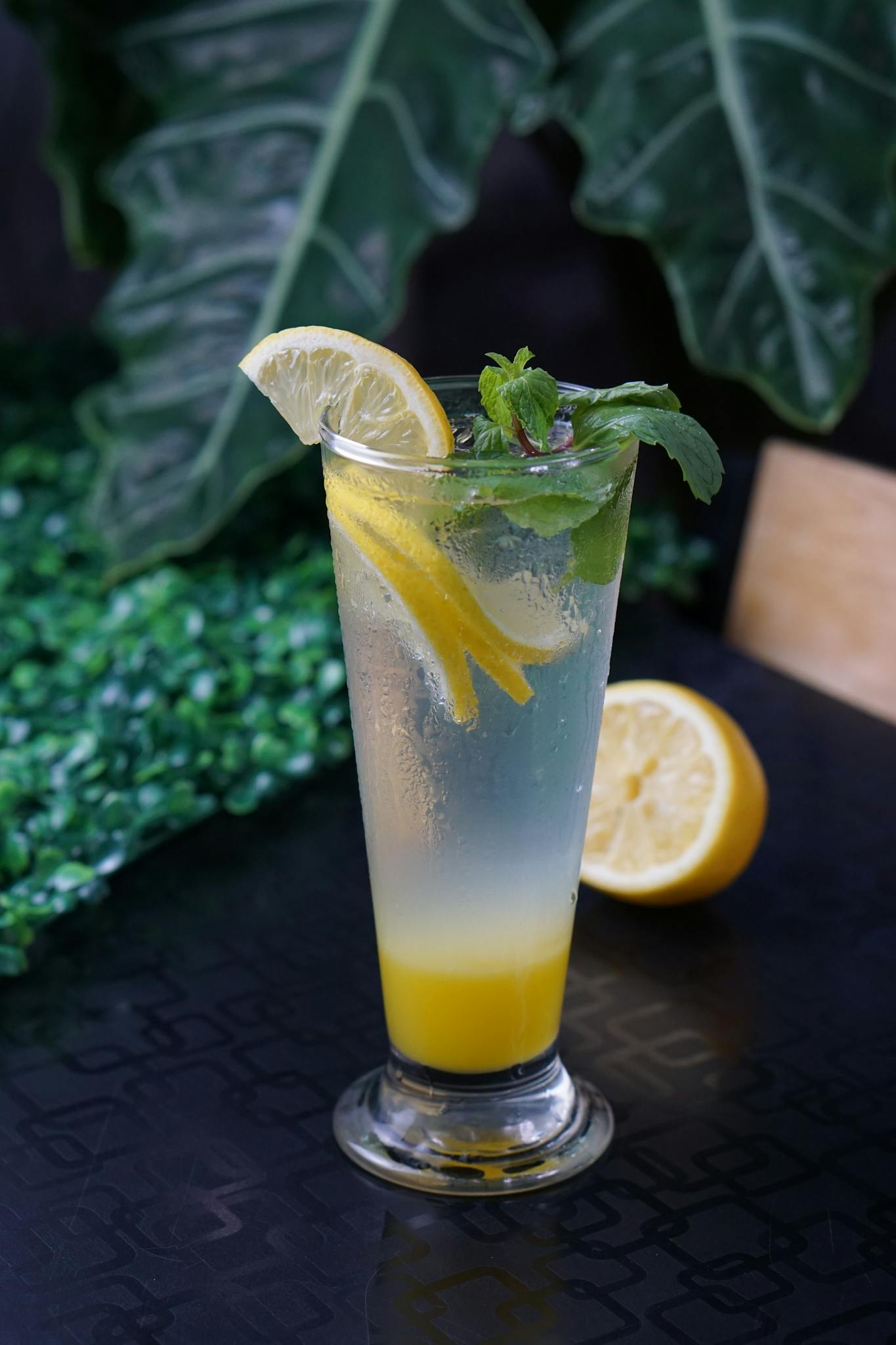 Chilled glass of mint lemonade with lemon slices, perfect for a hot day.