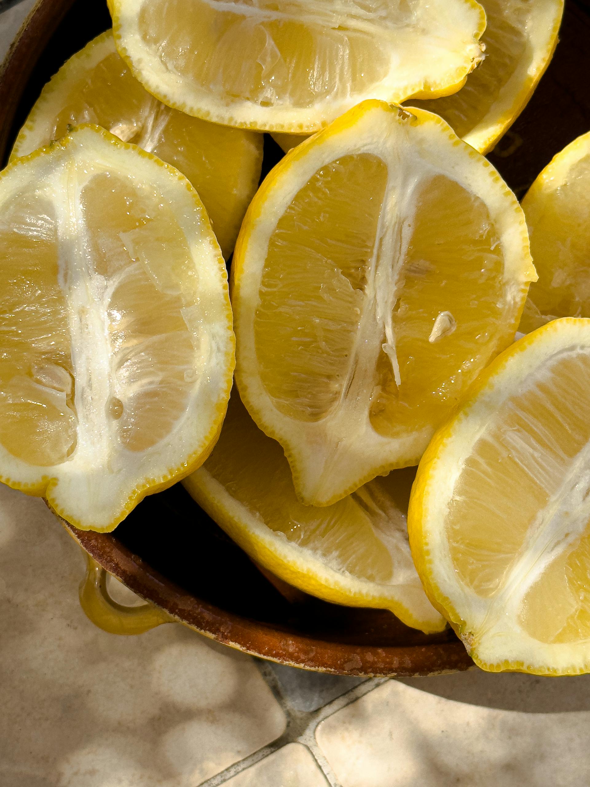 Close-up of fresh lemon slices in a basket with warm sunlight, perfect for food and lifestyle themes.